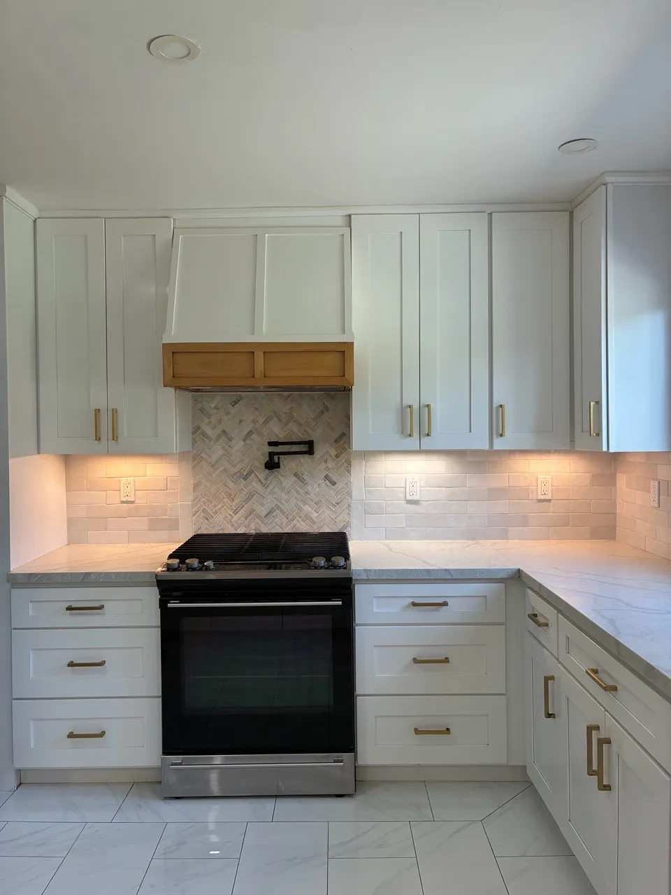 Bright white kitchen with a dark range and tiled backsplash