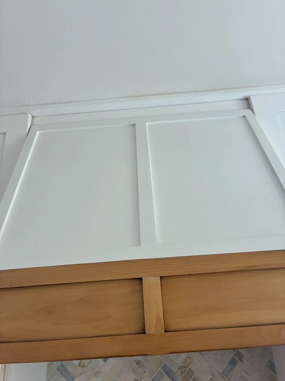 Close-up of white upper kitchen cabinets and tiled backsplash