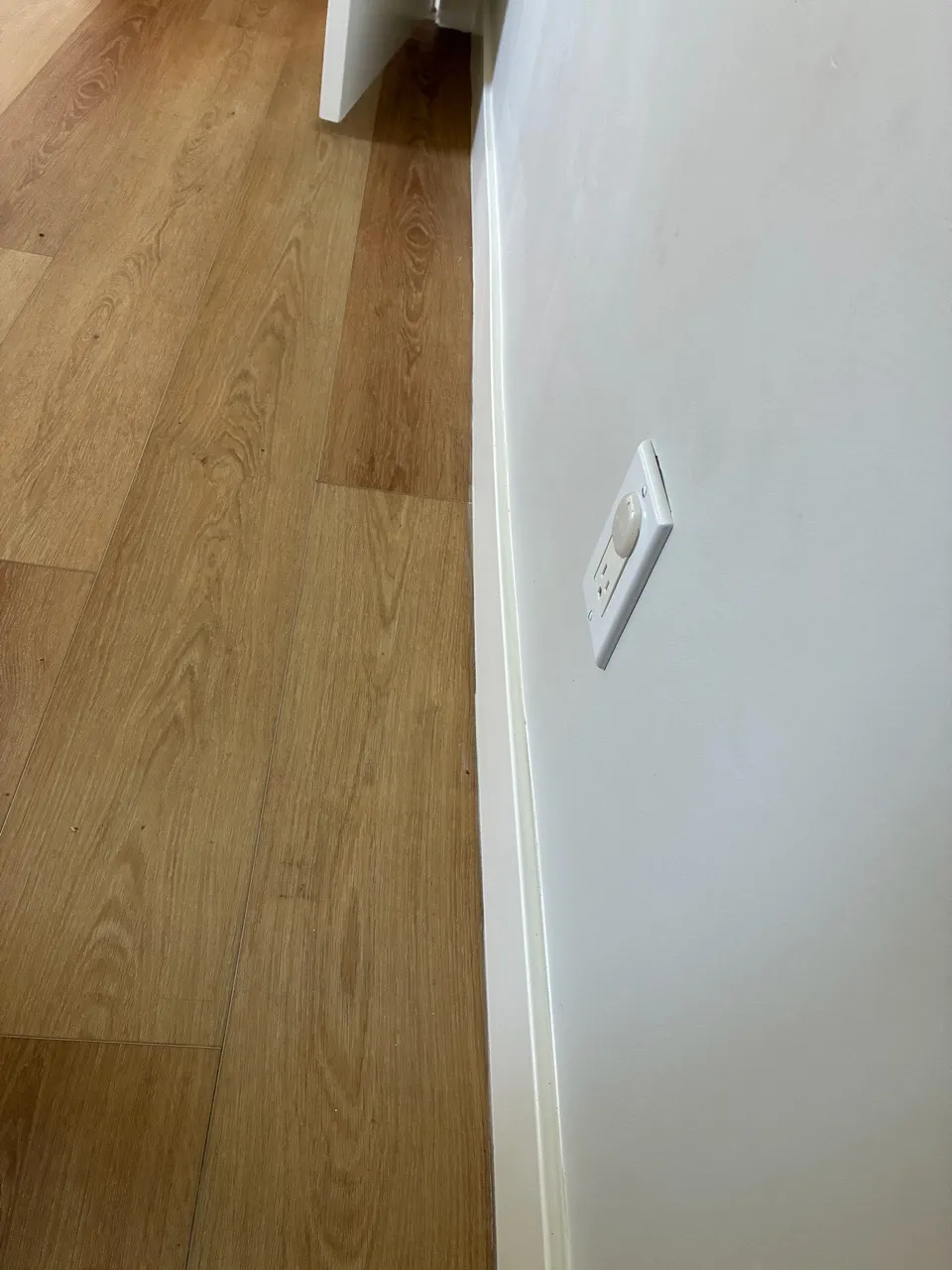 Wood flooring beside a clean white wall