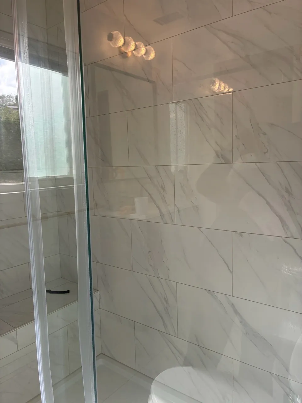 Tiled shower wall and glass enclosure