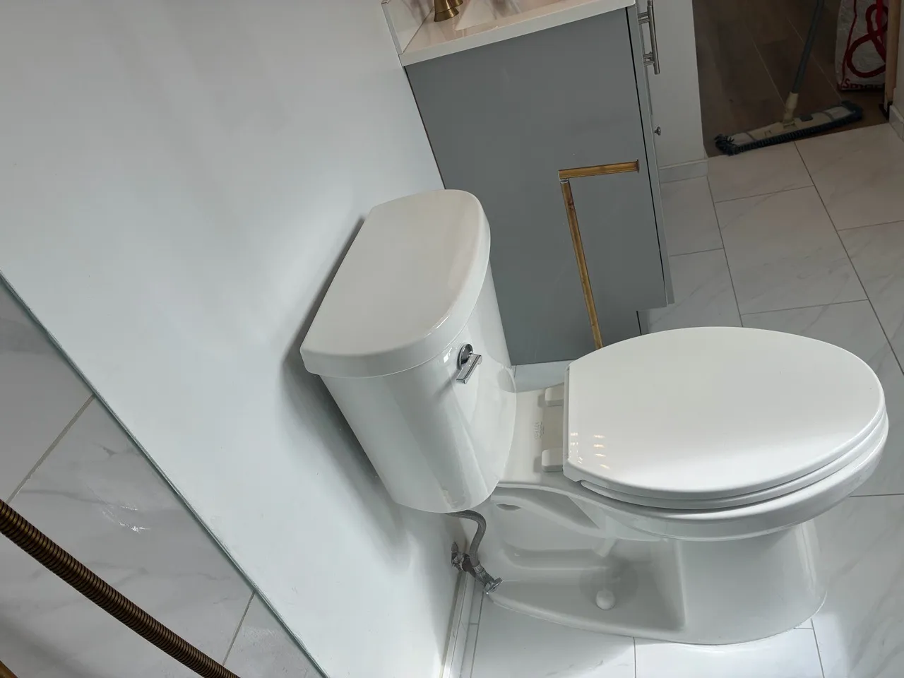 White toilet in a light tiled bathroom